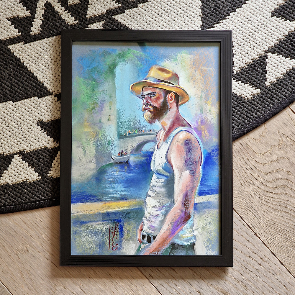Framed artwork of a man with a hat standing by a river